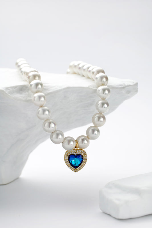 White shell pearl heart-shaped pendant necklace, carefully connected with pure white shell pearls, decorated with elegant heart-shaped pendant in the center, handcrafted and suitable for pet owners to wear in special occasions or daily life, showcasing a simple and elegant style